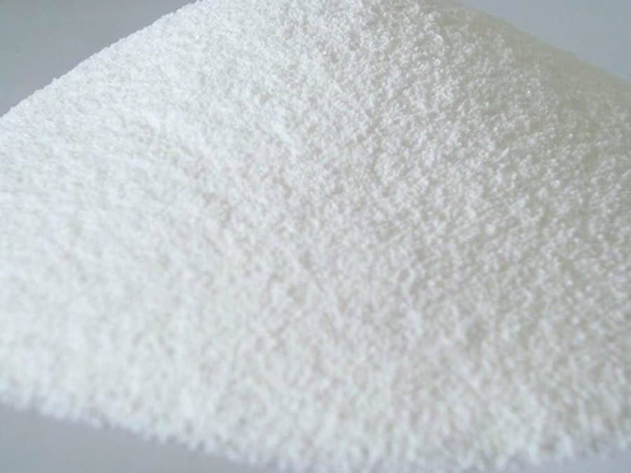 A heap of white calcium chloride anhydrous powder