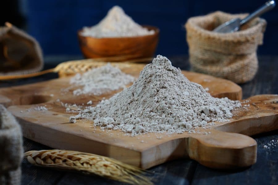 A pile of wheat flour on a wooden board